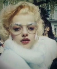 a woman with blond hair and glasses is posing in front of a crowd