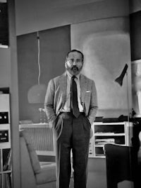 a man in a suit standing in a living room